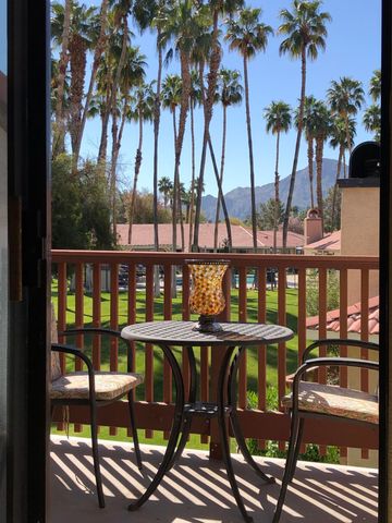 a view of a white house with a yard and potted plants