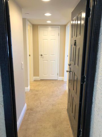 a view of a hallway with wooden floor and a door