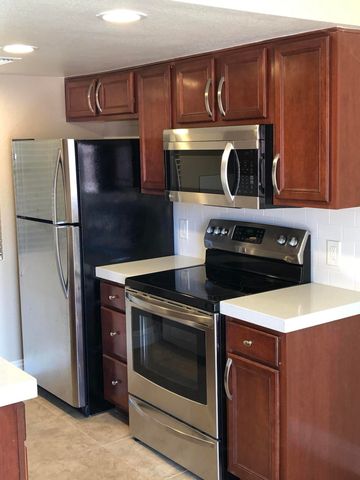 a kitchen with stainless steel appliances granite countertop a stove a refrigerator and a microwave