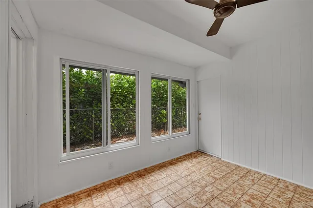 an empty room with white walls and ceiling fan