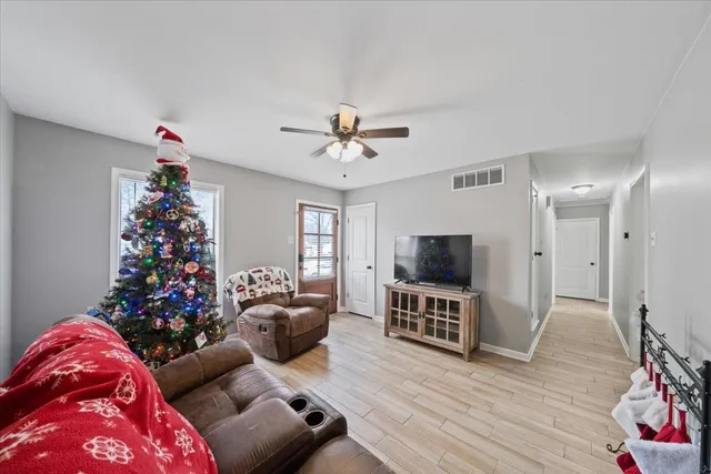 a living room with furniture a flat screen tv and a potted plant