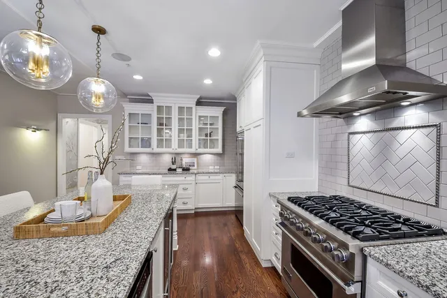a kitchen with granite countertop a stove and a wooden floors