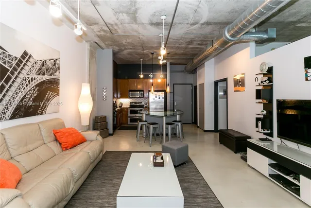 a living room with furniture a flat screen tv and a table
