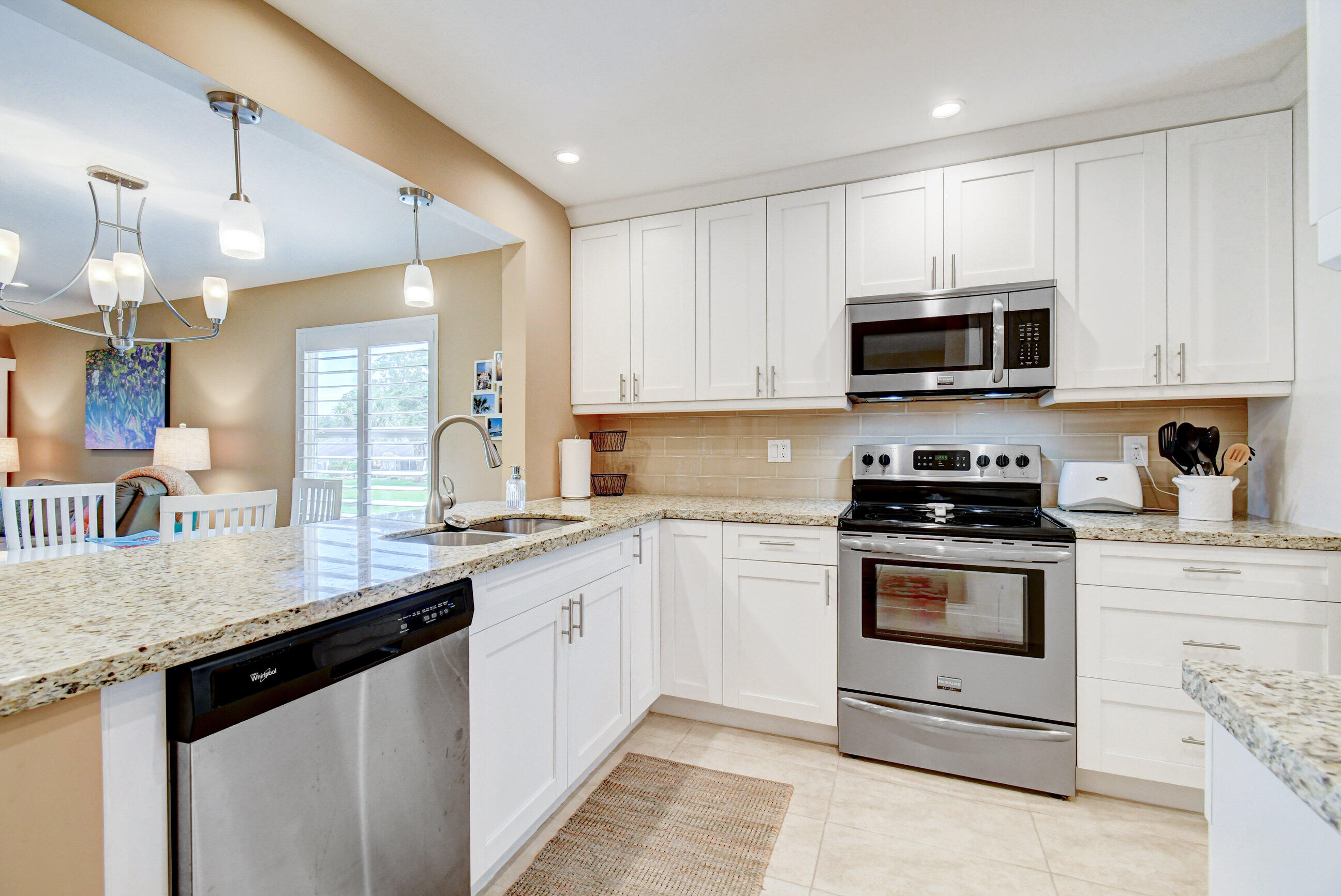 a kitchen with stainless steel appliances granite countertop a sink a stove top oven a counter space and cabinets