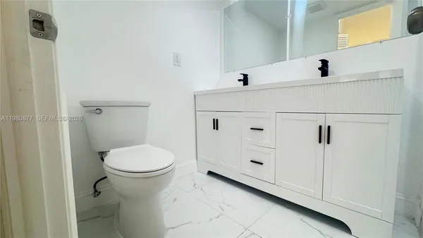 a white toilet sitting next to a bathroom sink