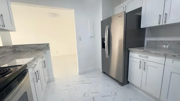 a kitchen with stainless steel appliances granite countertop a refrigerator and a stove