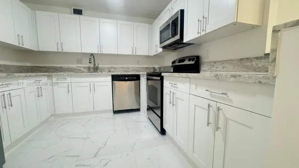 a kitchen with stainless steel appliances granite countertop a sink and a stove