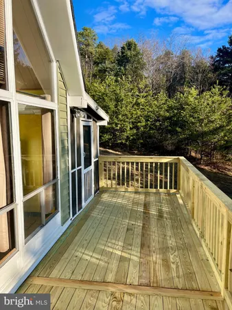 a view of a balcony with wooden floor and fence