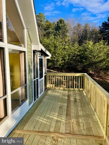 a view of a balcony with wooden floor and fence