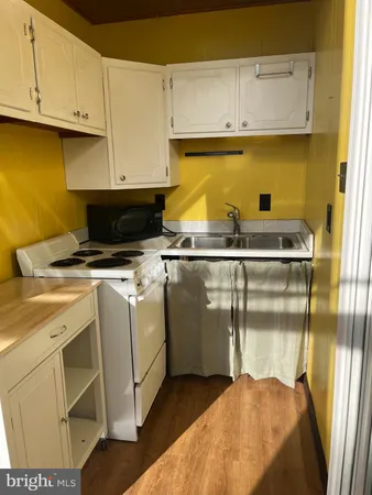 a kitchen with stainless steel appliances granite countertop a sink a stove and white cabinets