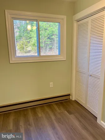 a view of a room with wooden floor and a window