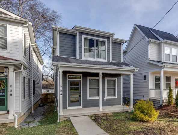 a view of a house with a yard and large window and potted plants