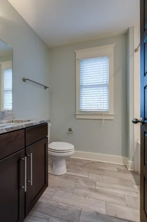 a bathroom with a sink a toilet and a window