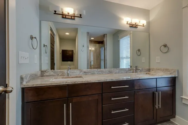 a bathroom with a granite countertop sink vanity and a mirror
