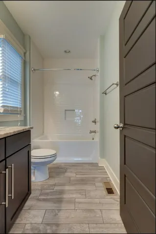 a bathroom with a toilet and a shower