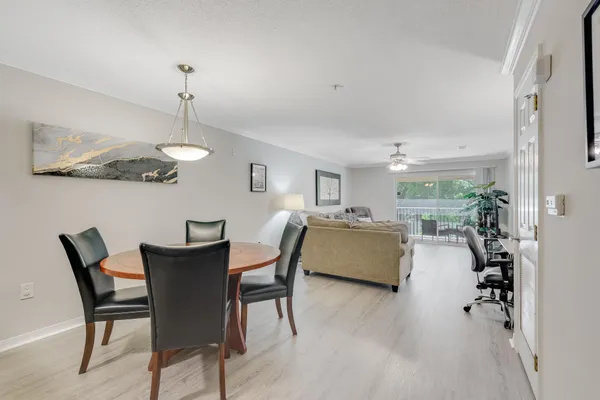 a dining room with furniture a chandelier and wooden floor