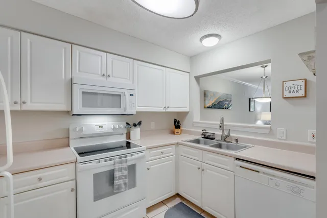 a kitchen with white cabinets sink and stove