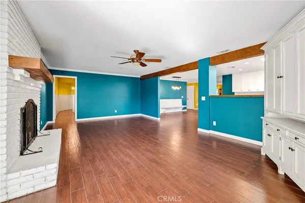 a view of a kitchen with kitchen island a sink wooden floor and a large window