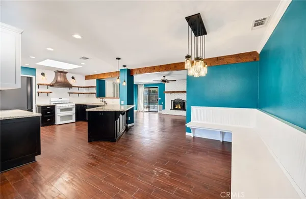 a kitchen with kitchen island a sink a stove and a wooden floor
