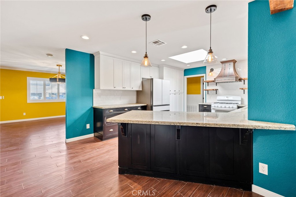 26655 Del Rosa Drive Hemet, CA 92544 - Photo 8 of 57 a kitchen with kitchen island a sink a stove and a wooden floor