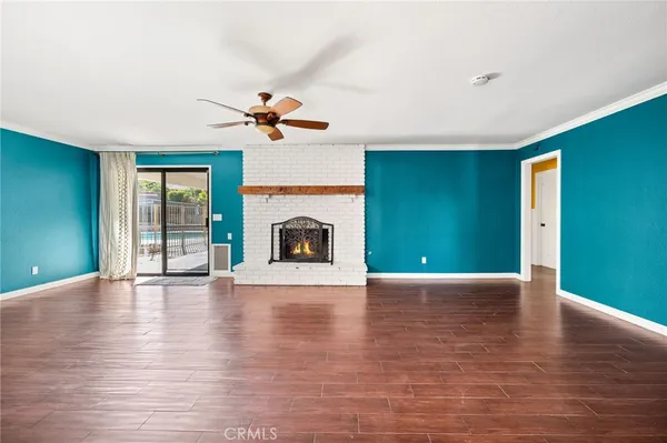 a view of empty room with fireplace and wooden floor