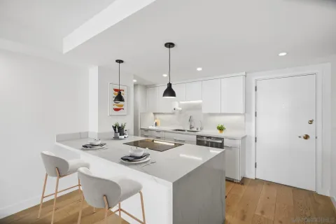 a kitchen with a sink a stove a refrigerator and white cabinets
