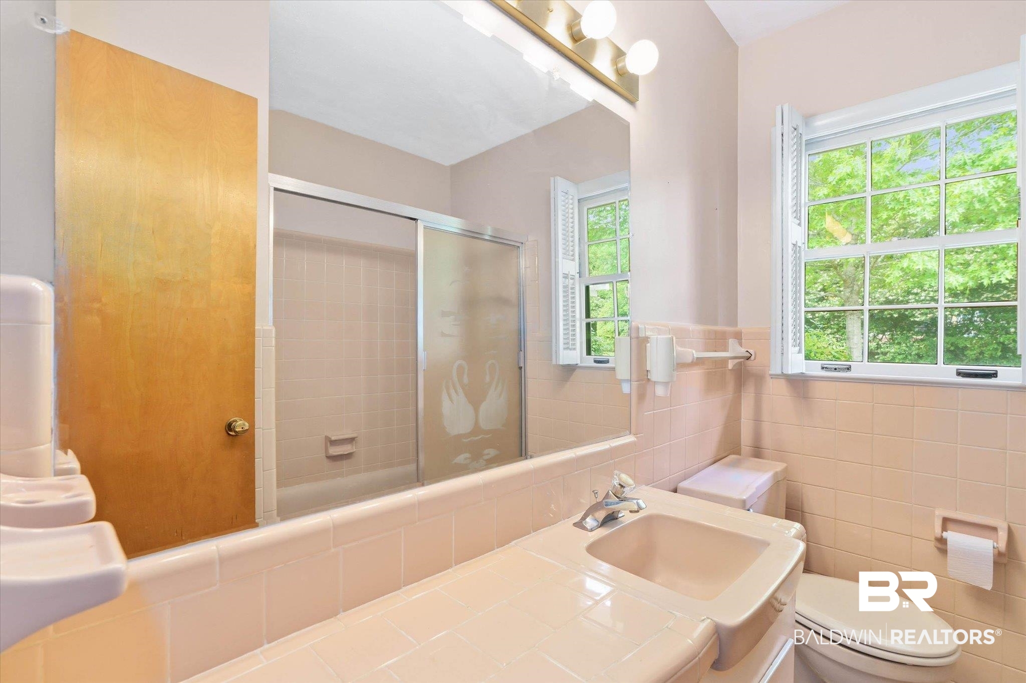 1182 Ginger Drive Mobile, AL 36693 - Photo 23 of 37 Bathroom with a tiled vanity featuring an integrated sink, a large wall-mounted mirror, and a window with white shutters
