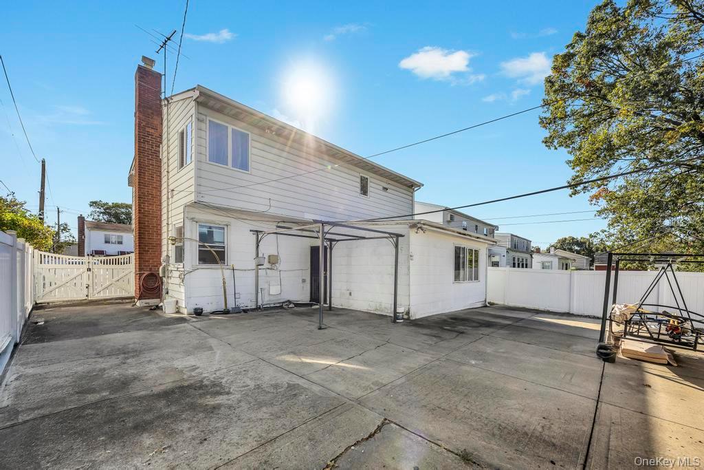 179 Sterling Road Elmont, NY 11003 - Photo 18 of 20 Rear view of house with a gate, a fenced backyard, and a chimney