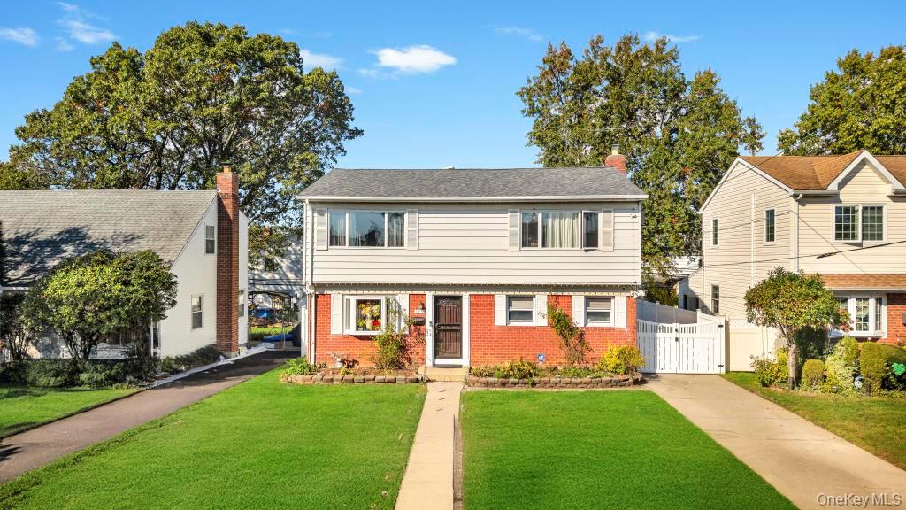 179 Sterling Road Elmont, NY 11003 - Photo 19 of 20 Colonial home featuring a gate, a front yard, brick siding, and a chimney