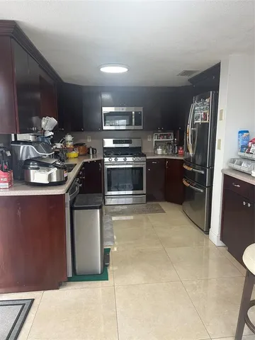 a kitchen with kitchen island a sink stove and refrigerator