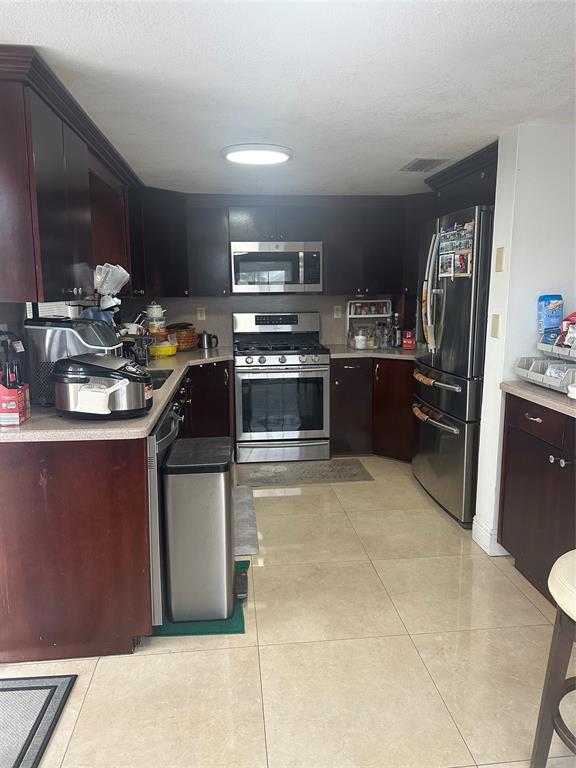 4753 Southwest 154th Court Miami, FL 33185 - Photo 13 of 30 a kitchen with kitchen island a sink stove and refrigerator