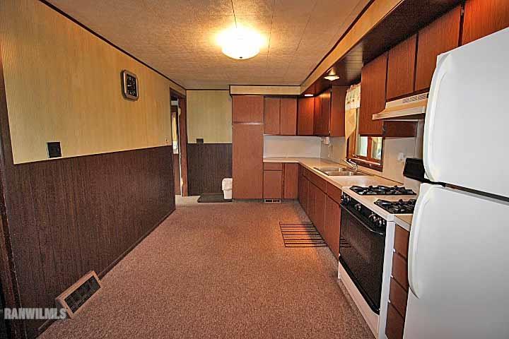 5347 West Richland Road Freeport, IL 61032 - Photo 16 of 20 a kitchen with stainless steel appliances granite countertop a refrigerator a stove and a sink with wooden cabinets