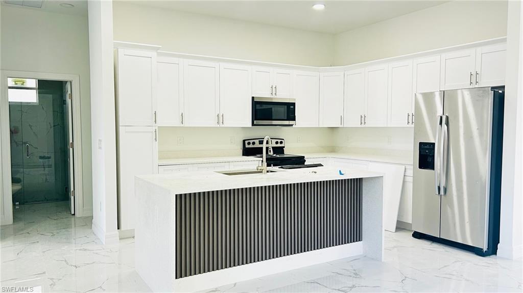 2958 70th Avenue Northeast Naples, FL 34120 - Photo 2 of 8 a kitchen with stainless steel appliances a sink stove and refrigerator