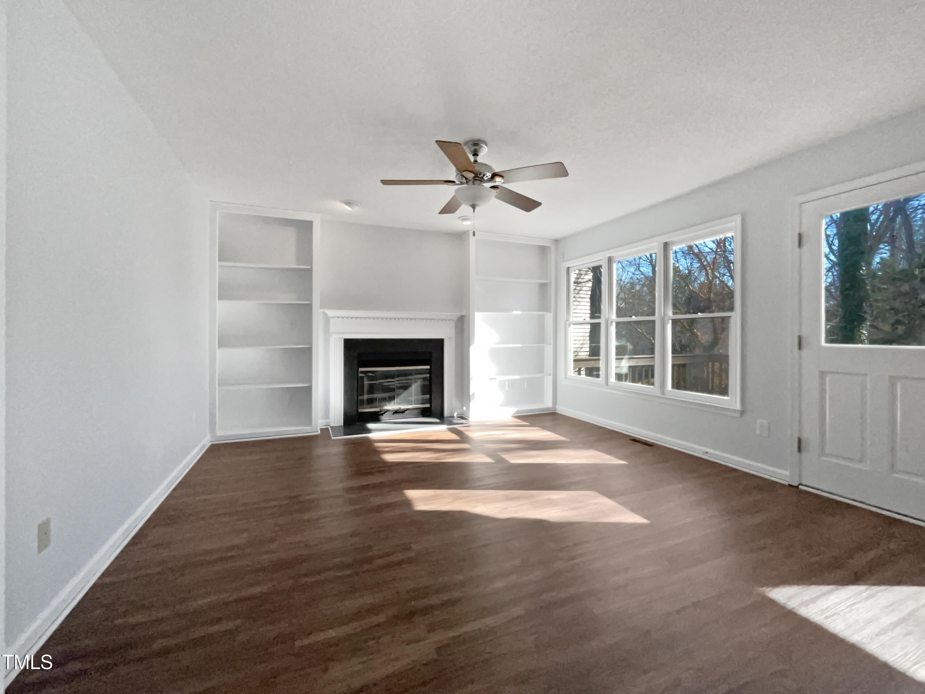 118 Trafalgar Lane Cary, NC 27513 - Photo 3 of 22 an empty room with windows fireplace and a kitchen view