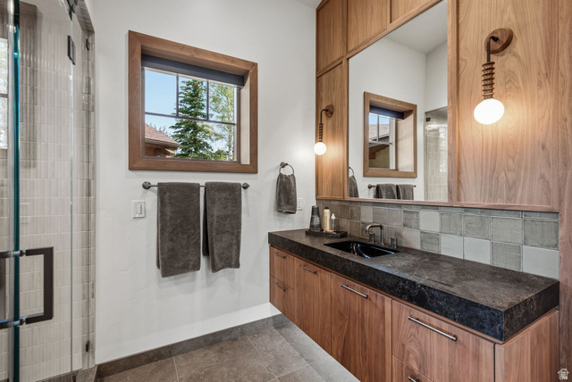 7885 North Rabbitbrush Court, Unit 13 Park City, UT 84098 - Photo 29 of 88 Bathroom with a dark stone countertop, an integrated black sink, and a wood-finish floating vanity