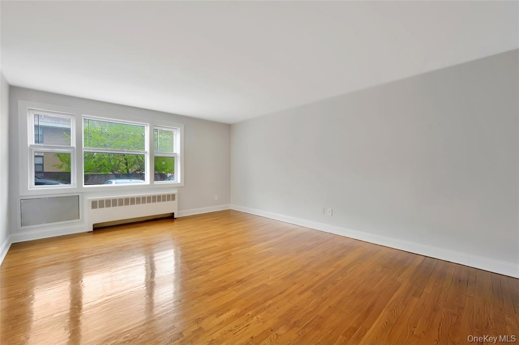 504 Pelham Road New Rochelle, NY 10805 - Photo 4 of 26 a view of an empty room with wooden floor and a window