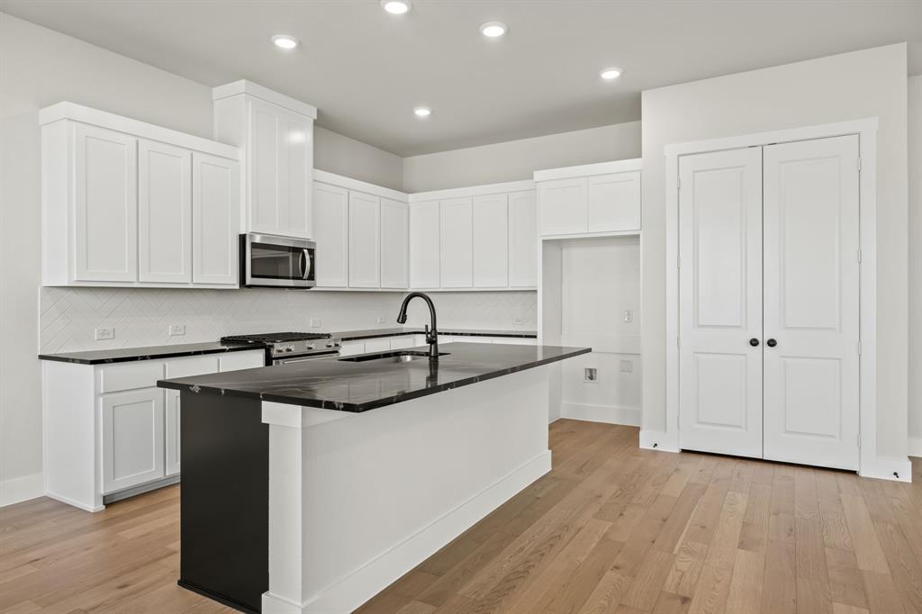 317 Chestnut Street Celina, TX 75009 - Photo 12 of 30 a kitchen with stainless steel appliances granite countertop a sink stove and refrigerator