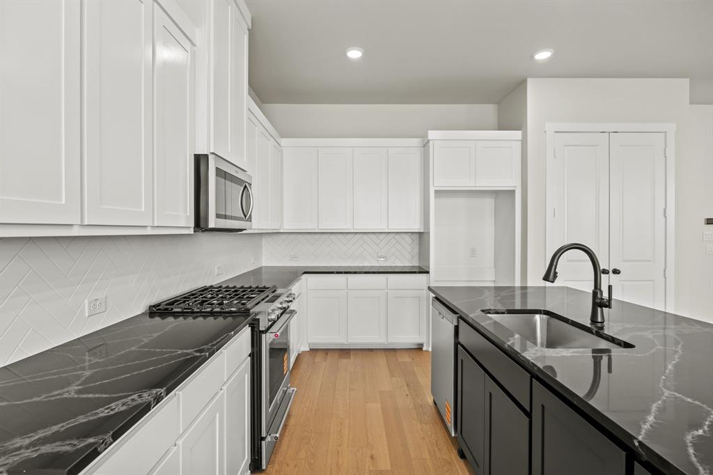 317 Chestnut Street Celina, TX 75009 - Photo 13 of 30 a kitchen with kitchen island granite countertop a sink a counter space and cabinets