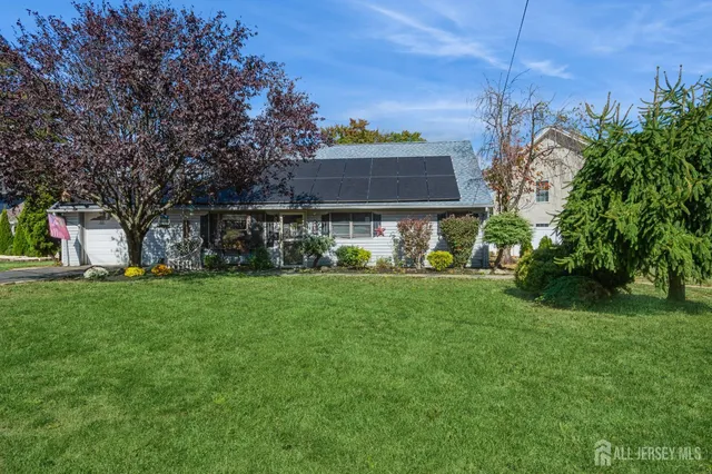 a view of a house with backyard and a tree