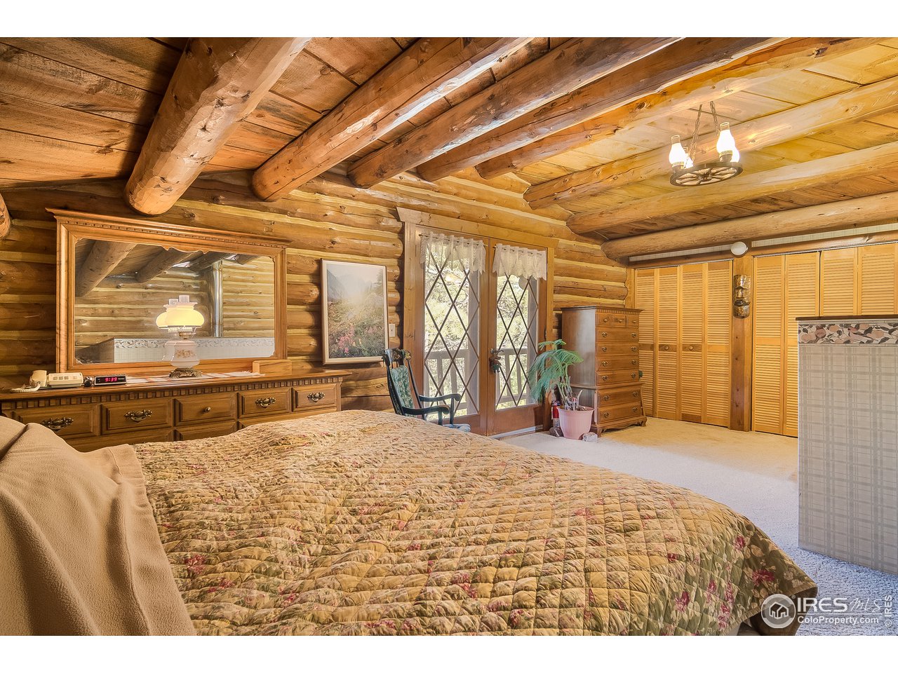 49 Moose Road Lyons, CO 80540 - Photo 33 of 40 a large bedroom with a bed and wooden floor