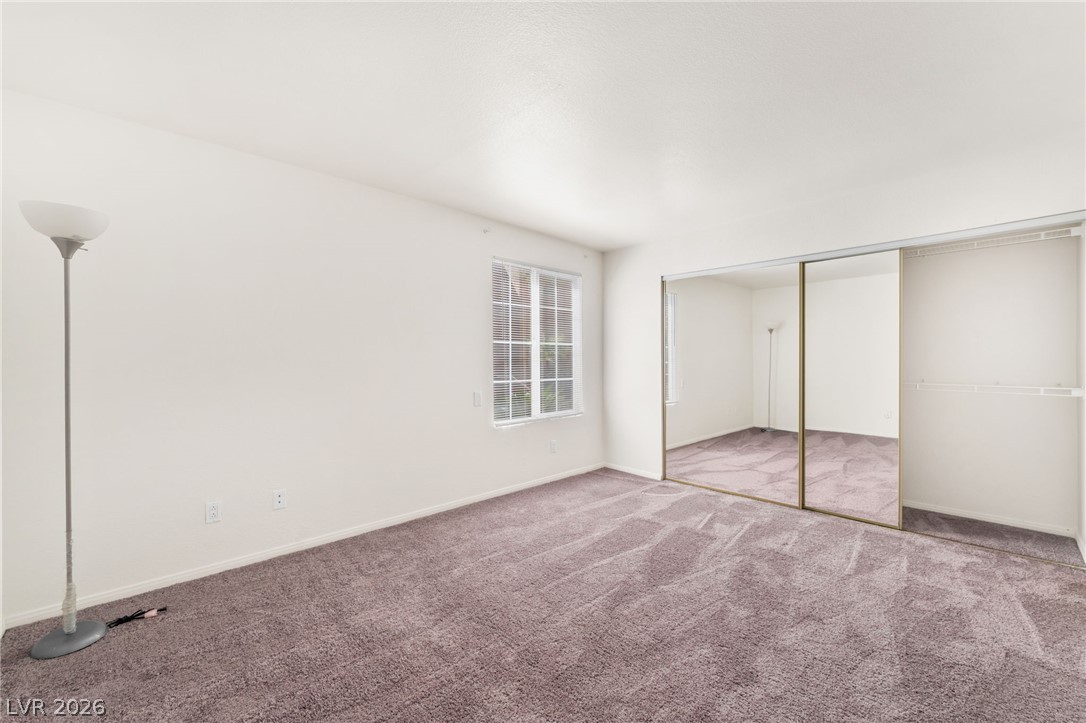 9325 West Desert Inn Road, Unit 177 Las Vegas, NV 89117 - Photo 12 of 24 Plush carpeting anchors this bedroom featuring a large closet with sliding mirrored doors.