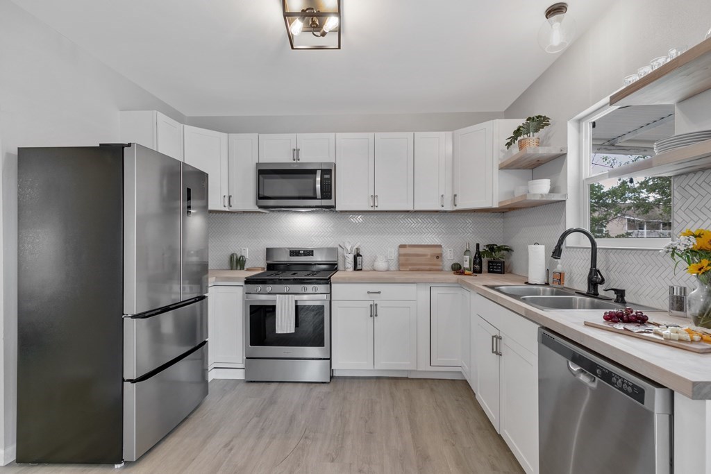 271 North Third Street Harper, TX 78631 - Photo 8 of 19 a kitchen with stainless steel appliances granite countertop a sink stove and refrigerator