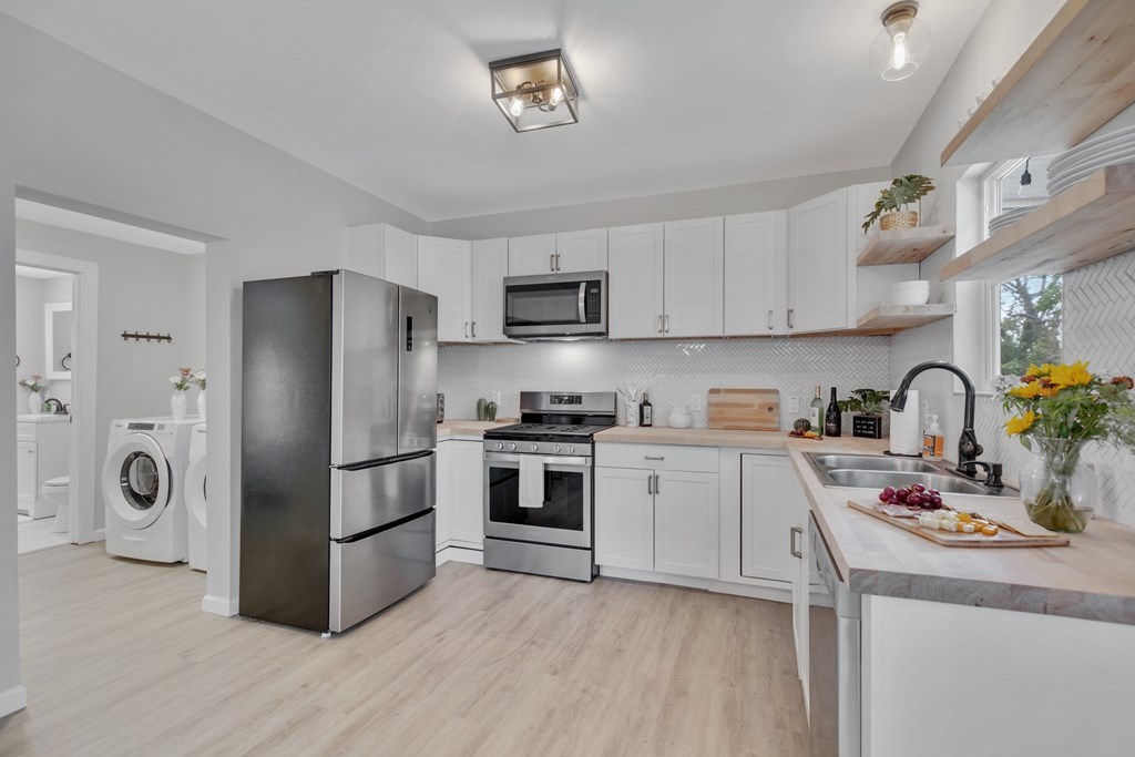 271 North Third Street Harper, TX 78631 - Photo 9 of 19 a kitchen with stainless steel appliances granite countertop a refrigerator stove and sink