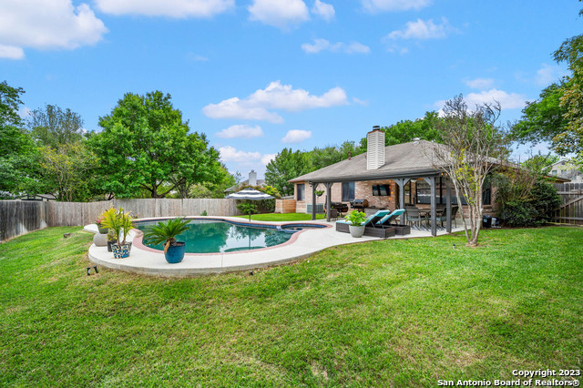 a front view of a house with garden and a yard
