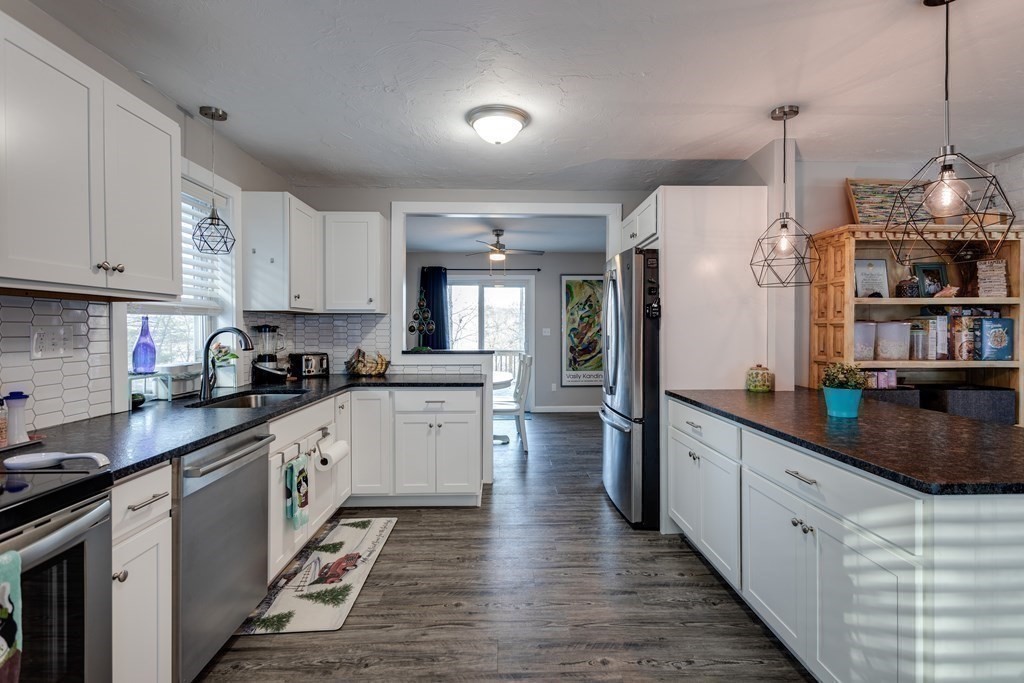 16 Vinton Road Holland, MA 01521 - Photo 13 of 32 a kitchen with stainless steel appliances granite countertop a refrigerator a sink dishwasher a stove and white cabinets with wooden floor