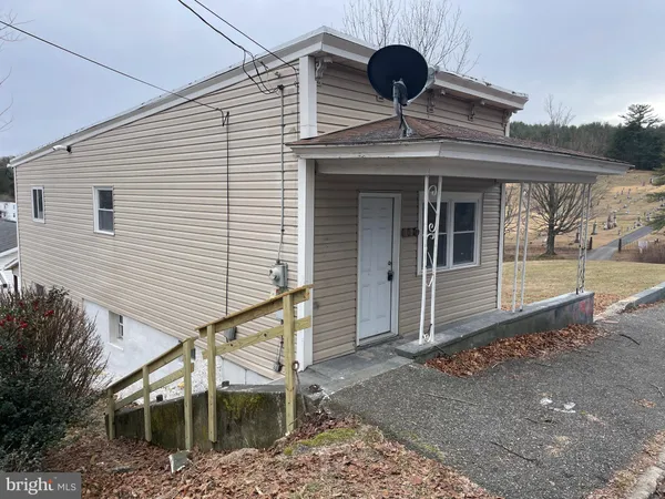 a front view of a house with a tree