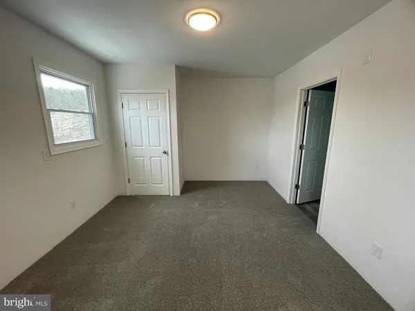 an empty room with windows and closet