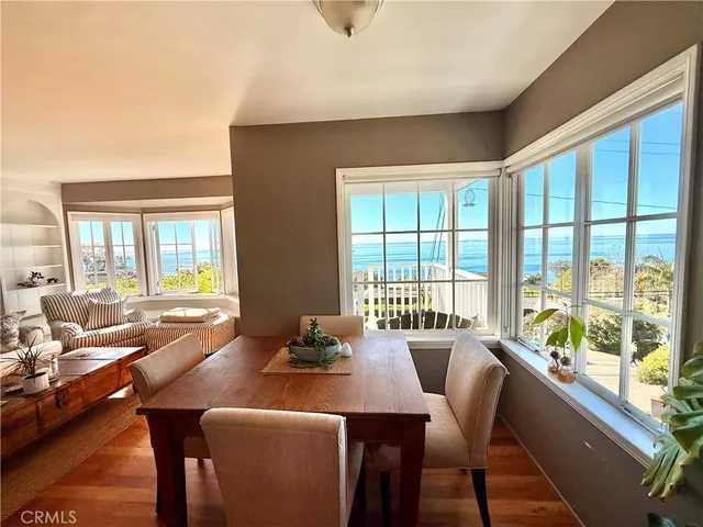 a view of a dining room with furniture large windows and wooden floor