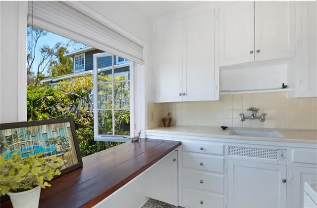a kitchen with granite countertop white cabinets a stove a dining table and chairs