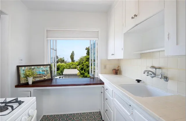 a kitchen with a sink cabinets and a window